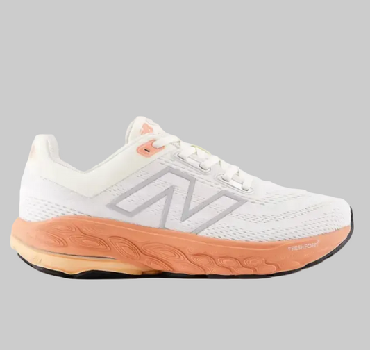 A New Balance running shoe in white mesh with a prominent orange midsole and a gray 'N' logo on the side, shown against a light gray background.