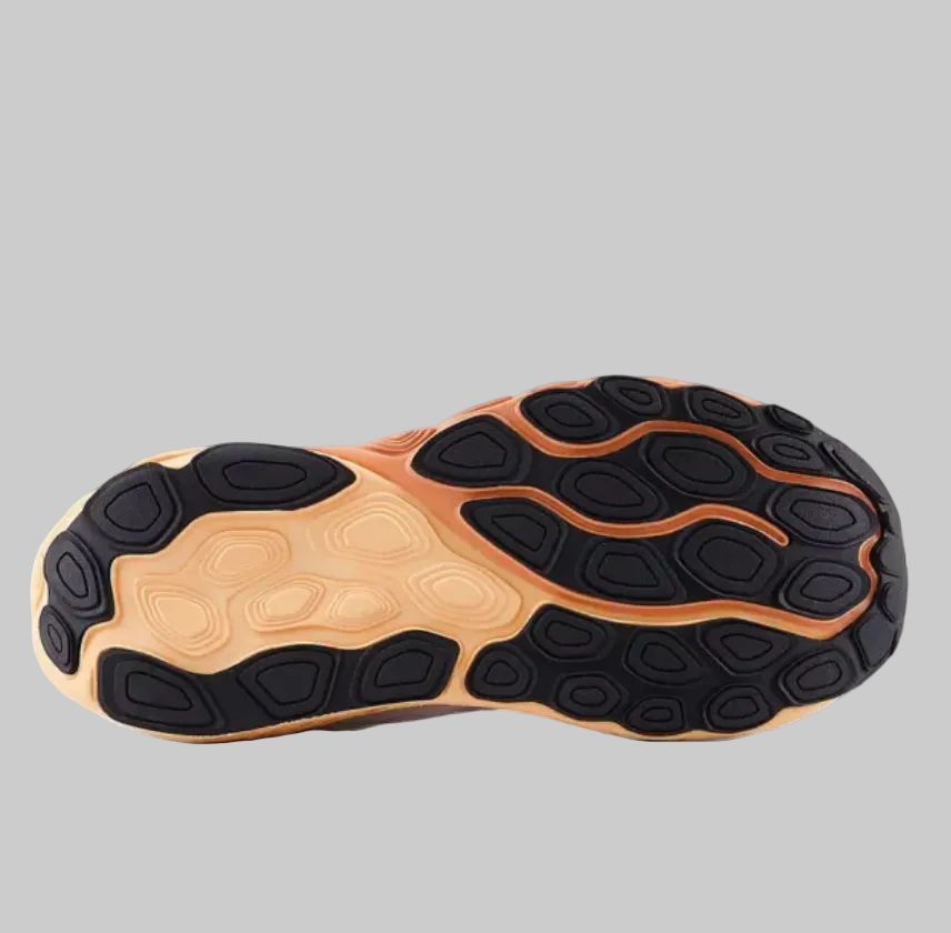 The outsole of a sneaker shown in a side profile view, featuring a black treaded pattern over a tan and orange-brown cushioned midsole on a light gray background.